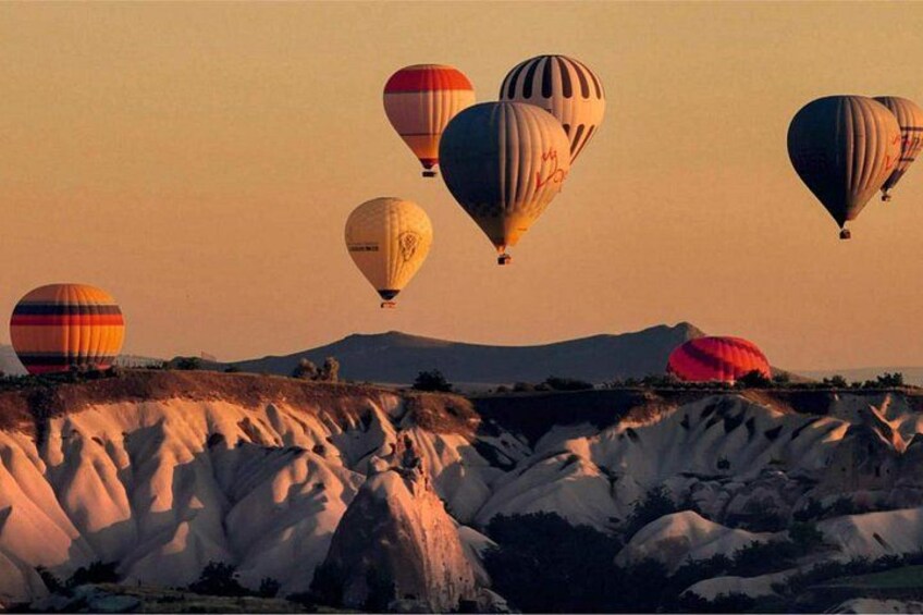 Hot air balloons over a rugged landscape with distinctive rock formations. 4