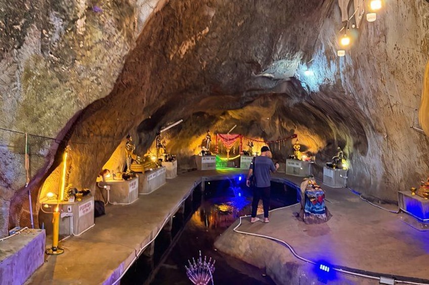A cave interior with statues and a person standing. 4