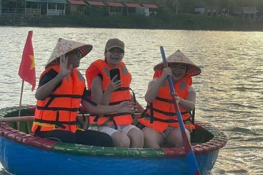 Three people in a boat wearing life jackets and hats, with a flag on the boat. 5