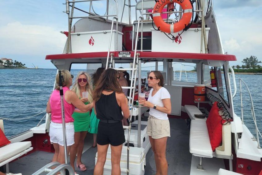 A group of people on a boat with life jackets and a ladder. 4