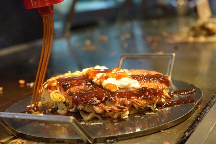 A dessert with toppings and sauce being poured over it. 2