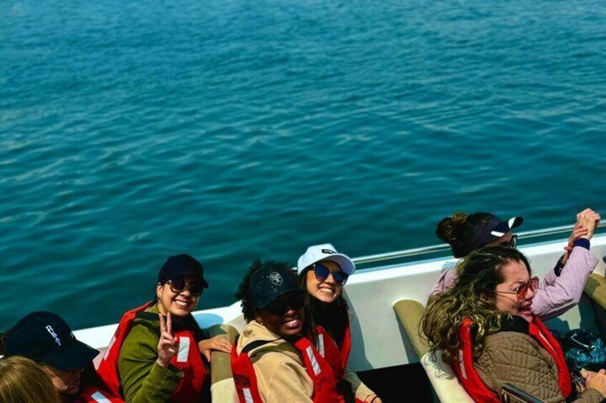 A group of people on a boat with water in the background. 2