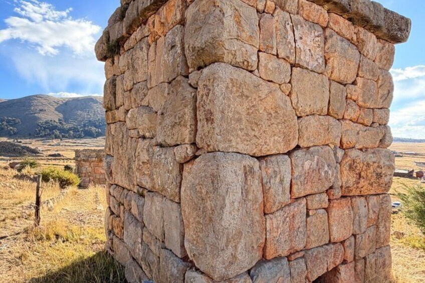 A stone wall with a mountainous landscape in the background. 5