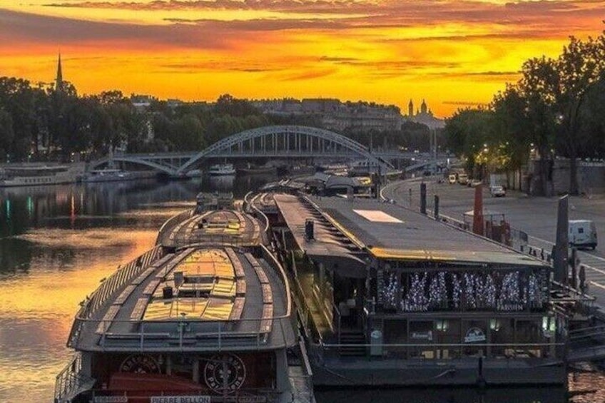 A riverboat on a bridge with a sunset in the background. 2