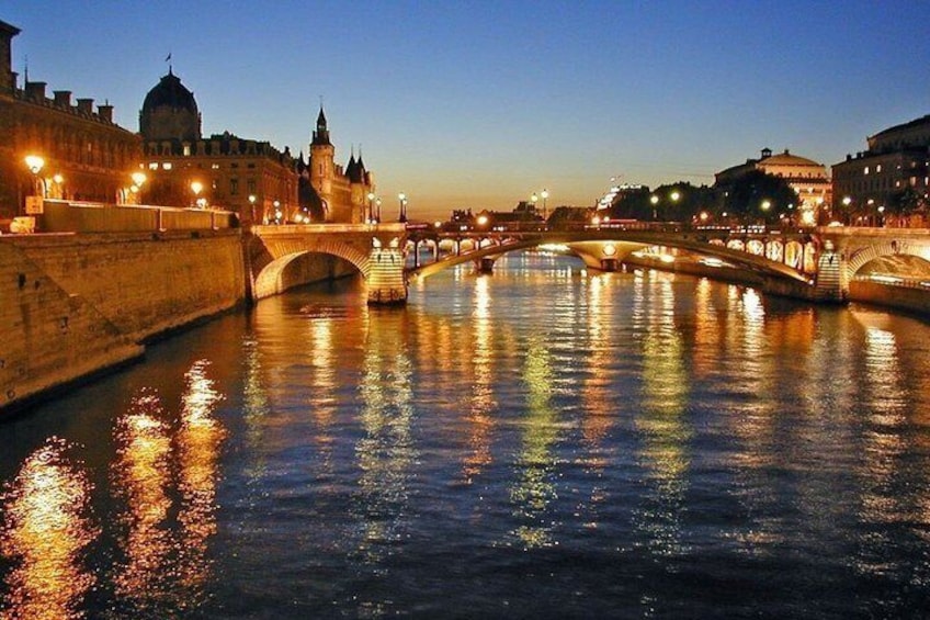 A river with bridges and illuminated buildings reflecting on the water. 4