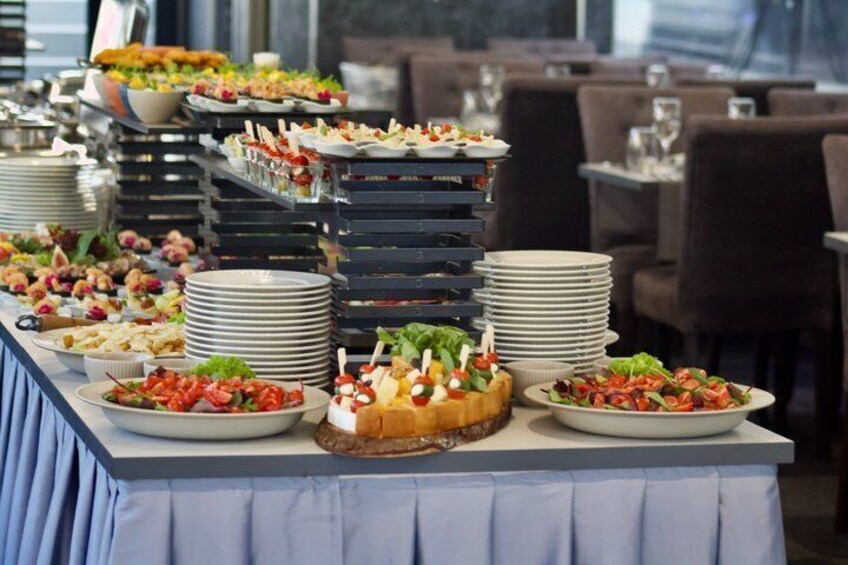 A buffet table with various dishes and plates. 1