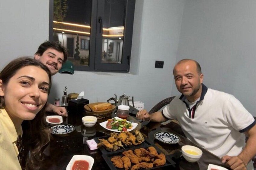 A group of people dining at a table with various dishes and condiments. 5