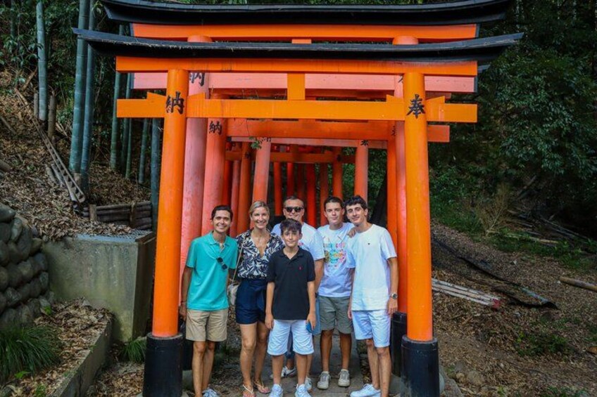 A group of people standing in front of a traditional Japanese torii gate. 3