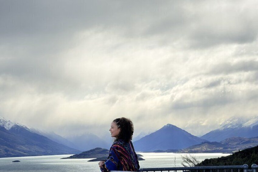 A person overlooking a mountainous landscape with a lake. 3