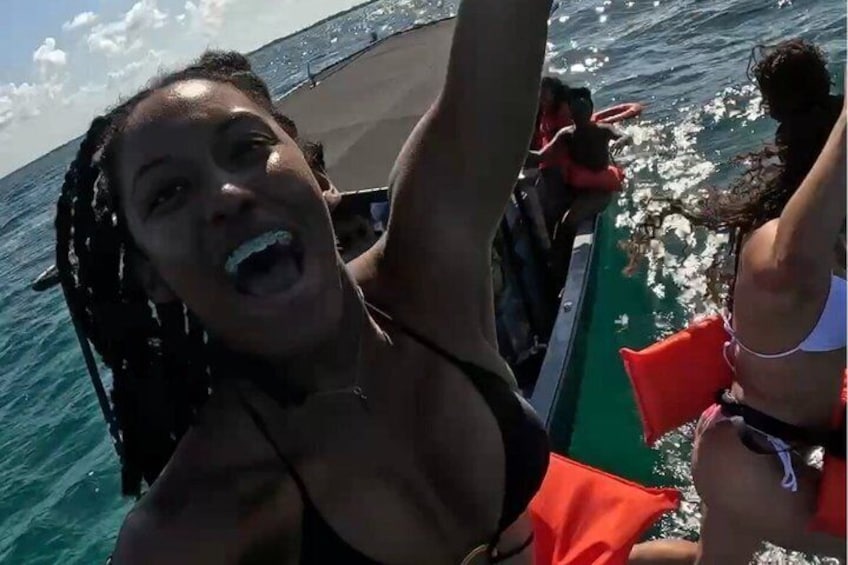 A person in a black swimsuit on a boat with a clear view of the ocean. 5