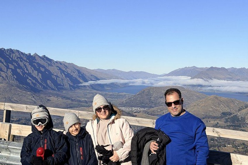 A group of people standing on a wooden platform with a mountainous landscape in the background. 5