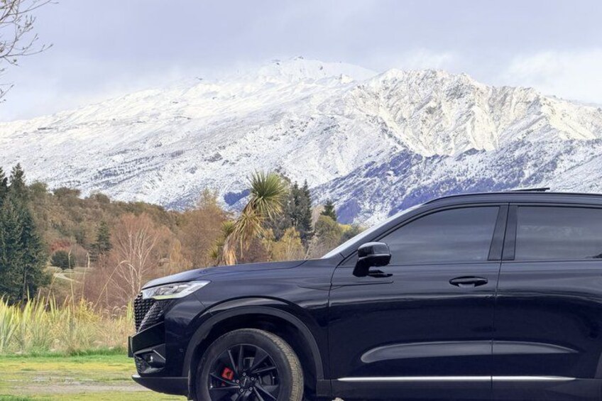 A black SUV parked with a mountainous landscape in the background. 2