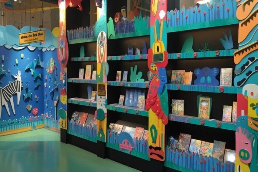 A colorful children's book display with whimsical illustrations and a blue wall with a sign. 4