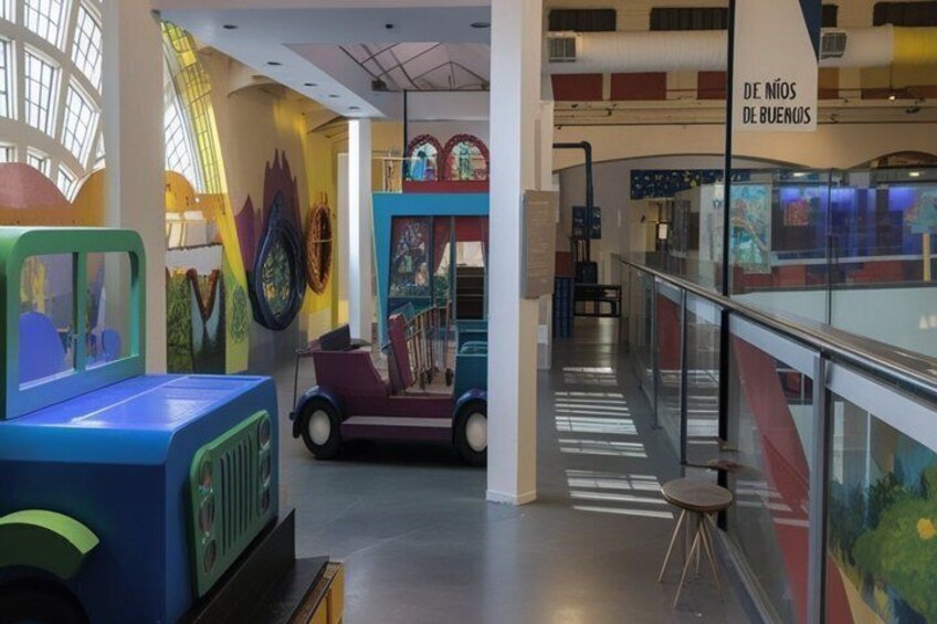 A colorful children's play area with a blue play structure and a red car ride. 5