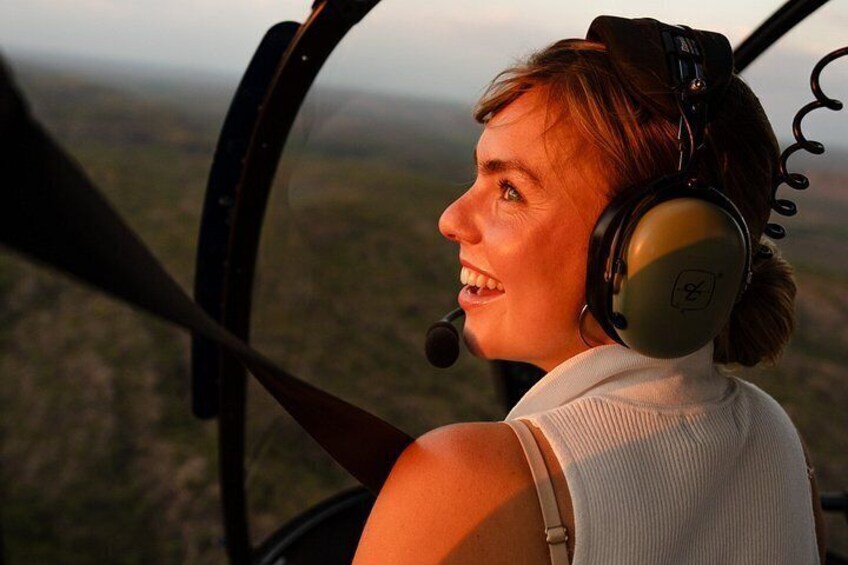 A person in a helicopter cockpit with a view of a landscape. 5