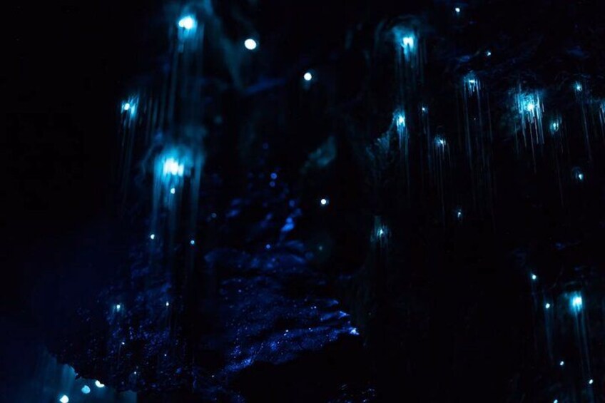 A dark scene with illuminated rock formations. 1