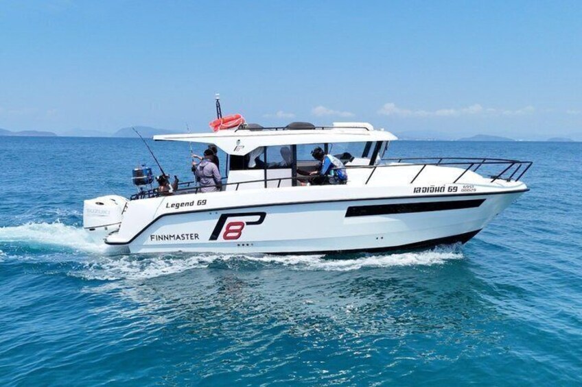 A white boat named 'Legend 69' with 'FINNMASTER' written on the side, sailing on blue water. 2