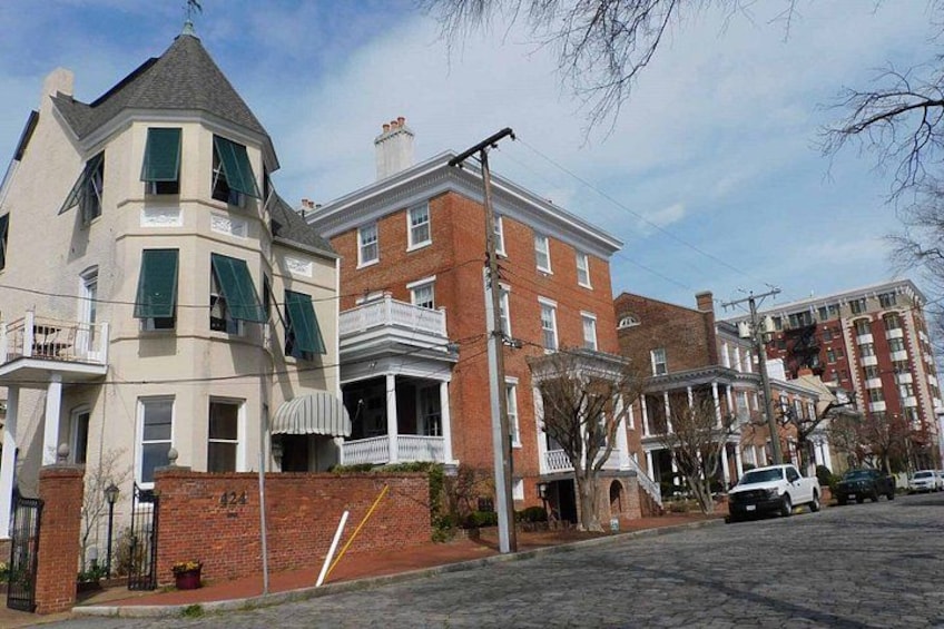 A row of townhouses with a brick facade and a corner building with a unique design. 2