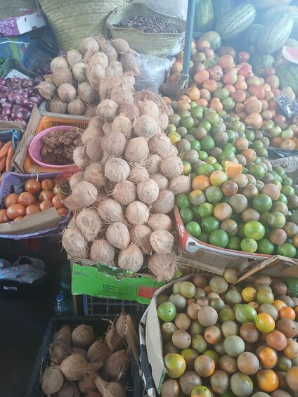 A market stall with coconuts, apples, and other fruits. 2