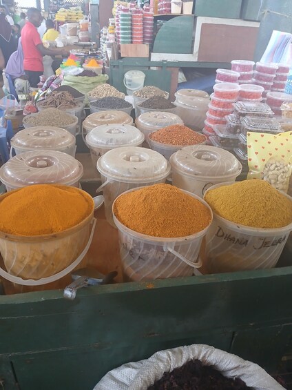 A market stall with various containers of grains and spices. 5