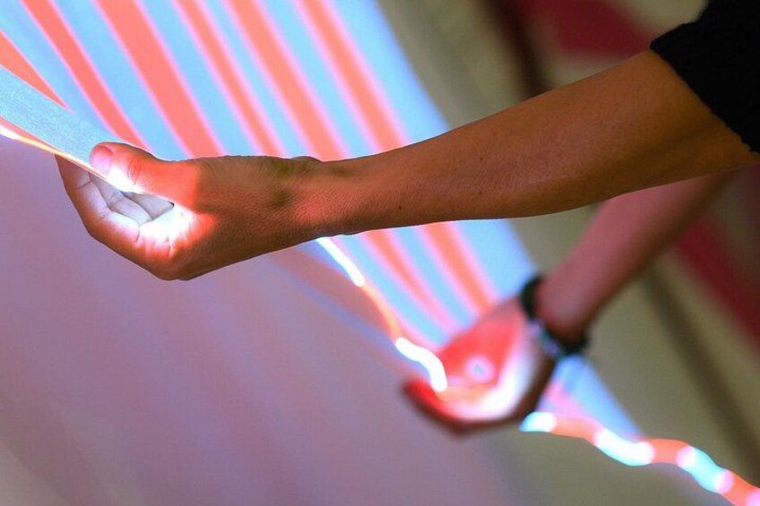A hand holding a glowing object with light patterns. 3