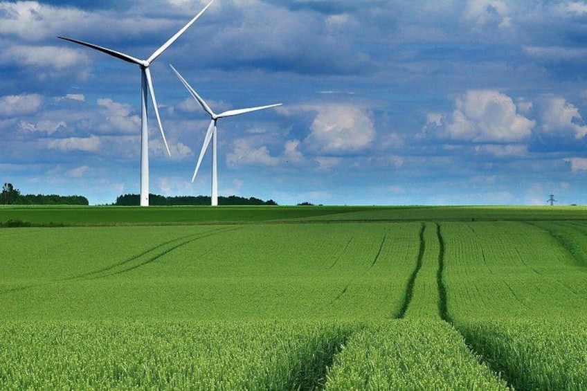 Wind turbines in a green field under a cloudy sky. 1