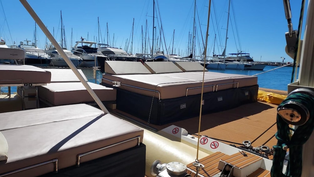 A boat deck with cushioned seating and a winch. 2