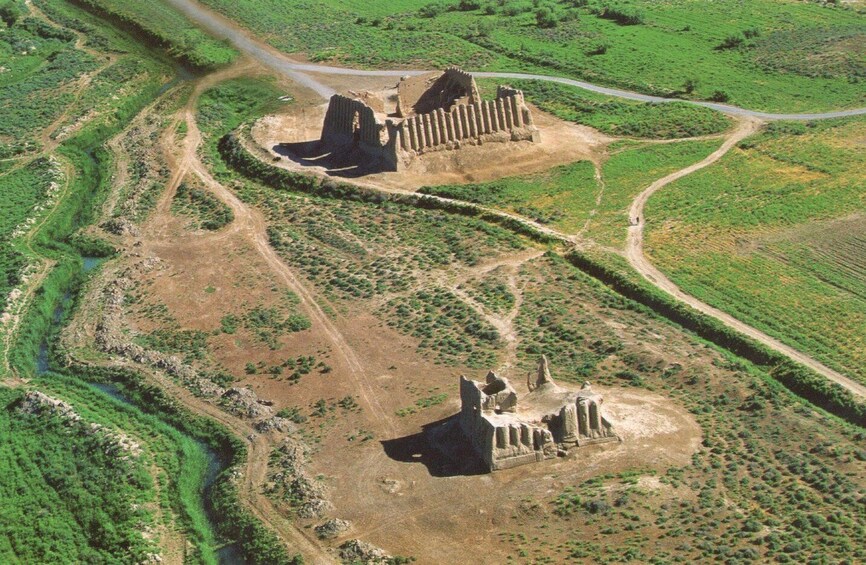 An aerial view of ancient ruins with a river and winding paths. 2