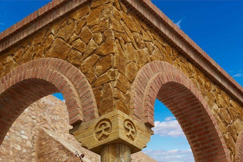 A stone bridge with arched passageways and a keystone with a hammer and sickle emblem. 2