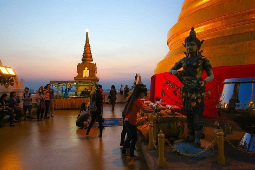 A large Buddha statue, a pagoda, and a market area with people and stalls. 3