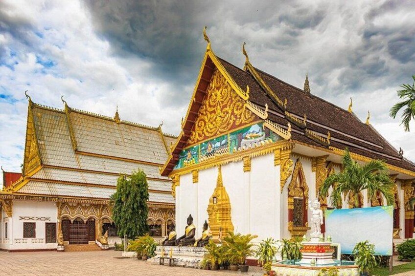 A traditional Thai temple with ornate architecture, a large Buddha statue, and a well-maintained garden. 4
