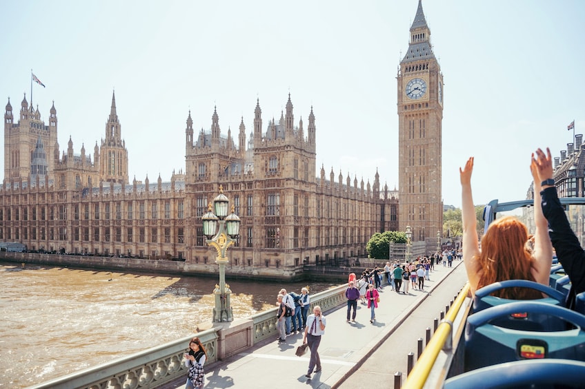 A river with a bridge, tourists, and the Big Ben clock tower in the background. 5