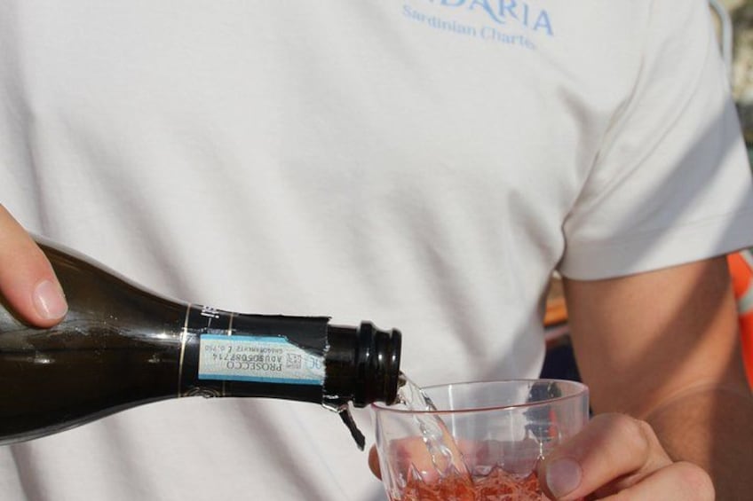 A person pouring a dark liquid from a bottle into a clear glass. 4