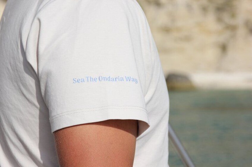 A person wearing a white t-shirt with 'Sea The Ondaria Way' printed on the back. 5