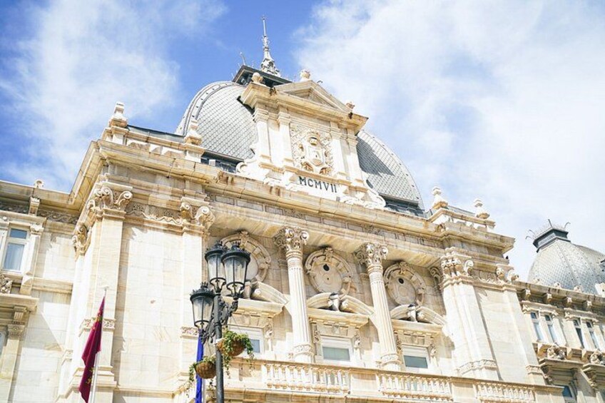 A grand building with ornate architecture, including domes and columns, and a clear blue sky in the background. 5