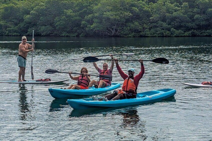 People kayaking on a calm lake surrounded by dense greenery. 3