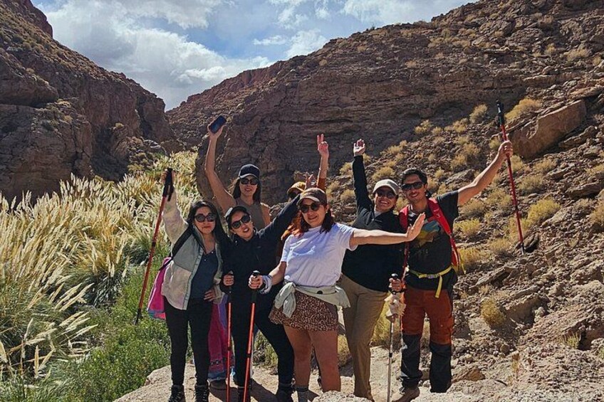 A group of hikers in a rocky canyon with sparse vegetation. 5