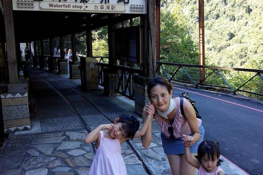 A woman and two children at a waterfall stop with a tram track. 2