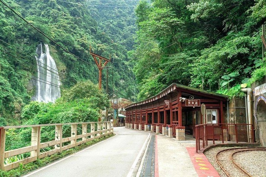 A train station with a waterfall in the background. 5