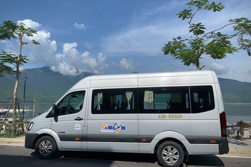 A white van parked by a lakeside with mountains in the background. 5