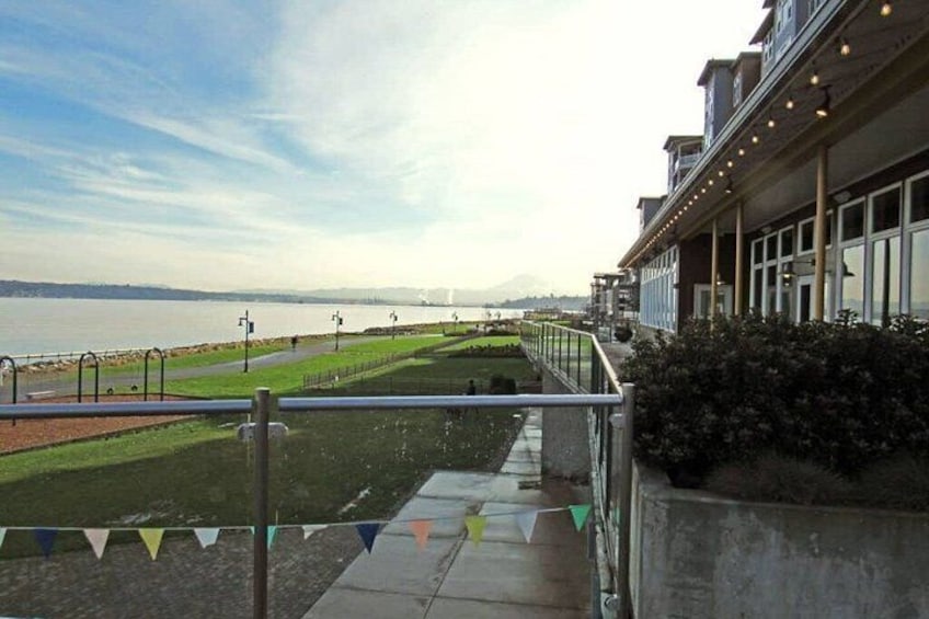 A waterfront promenade with a view of the sea and a bridge in the distance. 5