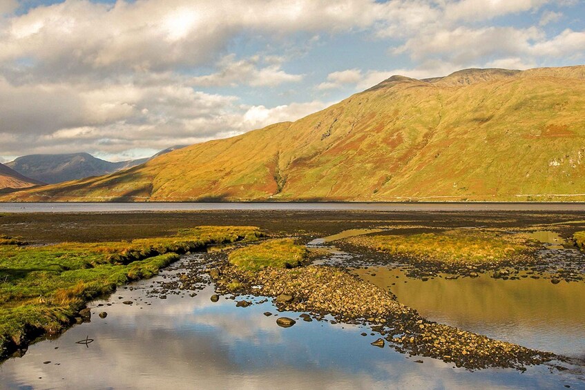 A mountainous landscape with a calm lake and a clear sky. 4