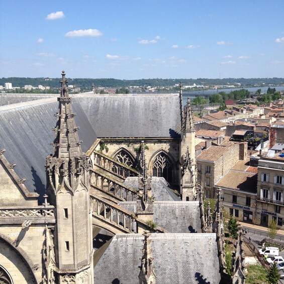 A cathedral with Gothic architecture, a large dam in the background, and a cityscape with buildings and a river. 4