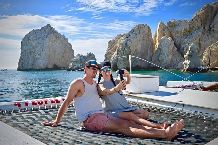 Two people on a boat with rocky cliffs in the background. 5