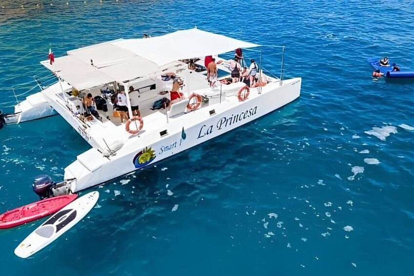 A white boat named 'La Princesa' with passengers and a smaller boat nearby. 3