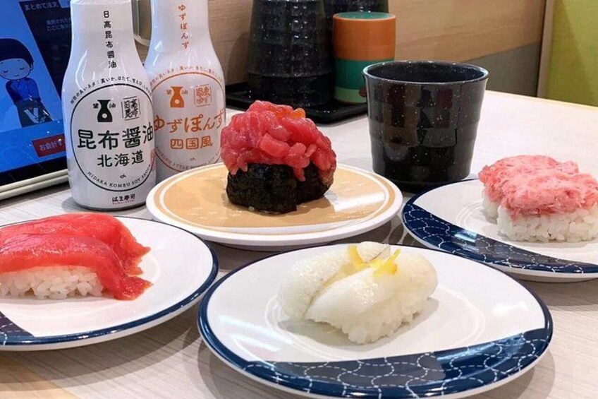 A variety of Japanese dishes on plates, including sushi and rice bowls, with condiments and a black mug on the table. 5