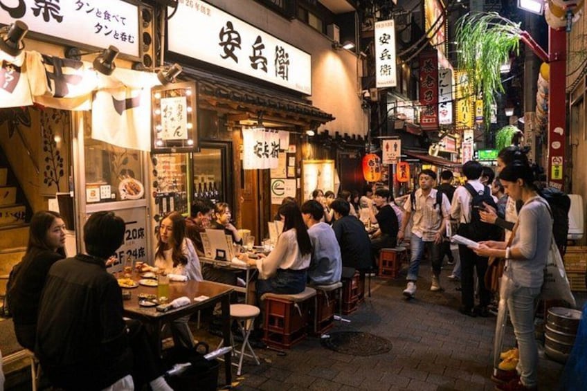 A busy street food market with people dining and walking around. 1