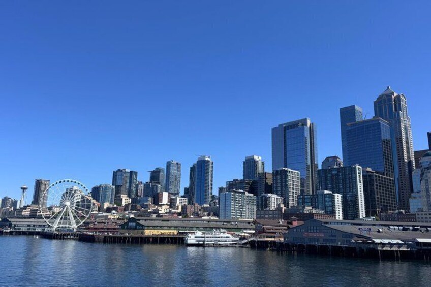 A city skyline with modern skyscrapers, a large Ferris wheel, and a waterfront with boats. 3