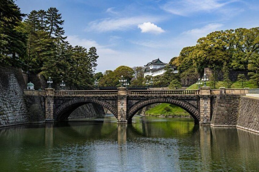 A stone bridge over a calm river, surrounded by lush greenery and traditional architecture. 3
