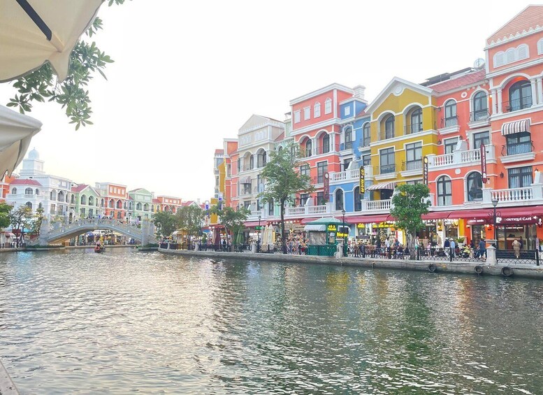 A colorful waterfront promenade with a bridge, shops, and cafes. 4